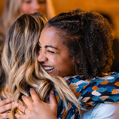 Two women hugging and smiling.