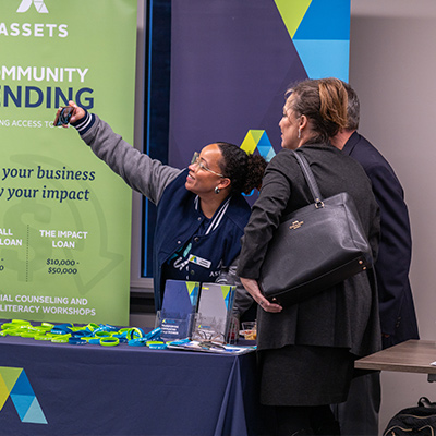 People taking a selfie at the Assets booth.