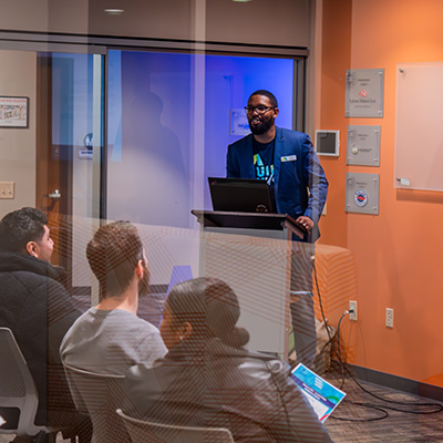 A man standing behind a podium in a meeting room.